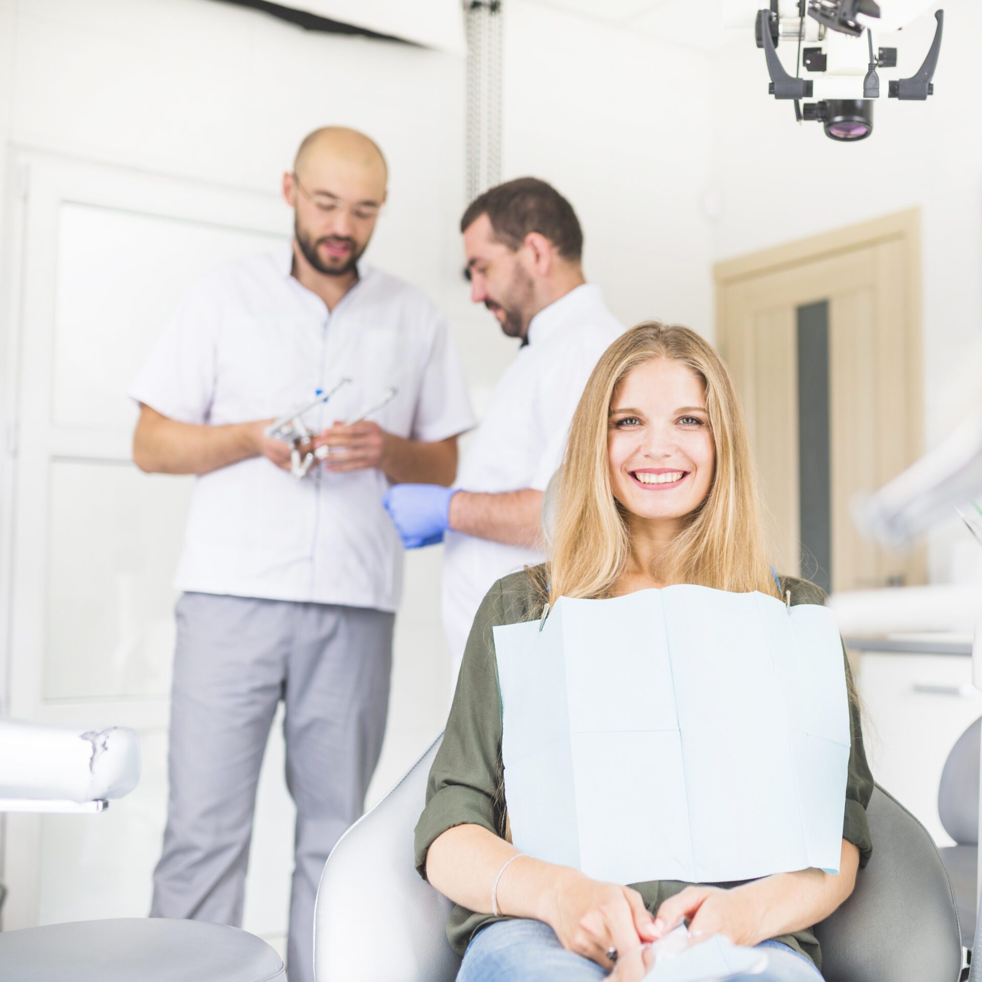 portrait-happy-female-patient-sitting-front-two-male-dentist